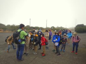 ホテルと溶岩台地の三原山頂上間をトレッキング。一面背の高い植物が消え、ザクザクというみんなの足音が変わります。